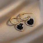 Black heart earrings in gold – Dramatic contrast